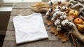 White cotton t-shirt folded on a rustic wooden table with natural decor Royalty Free Stock Photo