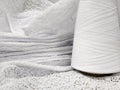 white cotton yarn in bobbins and fabric made from this yarn Royalty Free Stock Photo