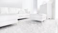 White couch in bright modern living room. Corner sofa with white cushions on white carpet Royalty Free Stock Photo