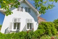 White country house and green bushes and trees under blue sky Royalty Free Stock Photo