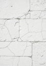 White cracked plaster wall with visible rectangular blocks. The surface is rough with Royalty Free Stock Photo