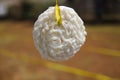 A white cracker hanging on a yellow raffia rope with defocused background. Royalty Free Stock Photo