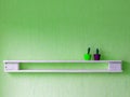white craft shelf hanging on green wall, minimalist design, wooden shelf made of pallets Royalty Free Stock Photo