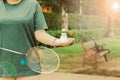 White cream badminton shuttlecocks and badminton rackets on hand,blurry tree background Ideas for sports in a healthy in park Royalty Free Stock Photo