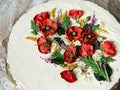 White cream cake decorated with buttercream flowers, Poppies, chamomile, cornflowers, spikelets of wheat, on gray background. Royalty Free Stock Photo