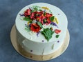 White cream cake decorated with buttercream flowers, Poppies, chamomile, cornflowers, spikelets of wheat, on gray background. Royalty Free Stock Photo