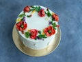 White cream cake decorated with buttercream flowers, Poppies, chamomile, cornflowers, spikelets of wheat, on gray background. Royalty Free Stock Photo