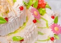 White cream cake decorated with cherries, sweet flowers and sedated dessert leaves festive