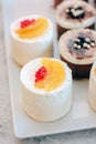 White cream cakes with fruits and berries in a restaraunt.