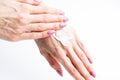 White cream on a woman's hand on a white background .Woman at home spa creaming hands close up photo
