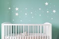 white crib against a pastel blue wall with star decals