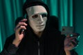 White criminal mask calling to credit card owner to threaten ransom. Pecuniary.