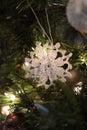 White crochet snowflake ornament hanging on Christmas tree