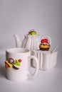 White crockery for tea drinking. The decor on the dishes is in the form of sweets. Cup, sugar bowl and teapot. Good Royalty Free Stock Photo