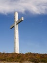 White cross against blue cloudy sky background. Concept catholic religion Royalty Free Stock Photo