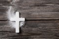 White cross with feather on an old rustic background. Royalty Free Stock Photo