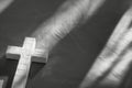 a white cross, with shadow, on a grey background