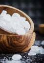 White crystal candy sugar in wooden bowl on black table, selective focus Royalty Free Stock Photo