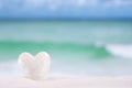 White crystal heart on white sand beach