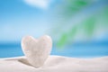 White crystal heart on white sand beach Royalty Free Stock Photo