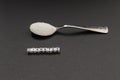 White crystal sugar on a small spoon with the inscription diabetes..Campaign to reduce sugar consumption