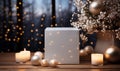 White cube with christmas balls and burning candles on wooden table against blurred background.. Royalty Free Stock Photo