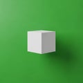 A white cube floats against a vibrant green background. The cube\'s smooth, sharp edg Royalty Free Stock Photo