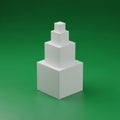 White cubes form a pyramid like structure on a smooth green backgroun Royalty Free Stock Photo