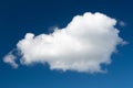 A white cumulus cloud against a dark blue daytime sky. A high resolution Royalty Free Stock Photo