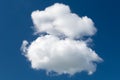 A white cumulus cloud against a dark blue daytime sky. A high resolution Royalty Free Stock Photo