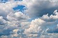 White Cumulus Clouds And Grey Storm Clouds On Blue Sky