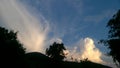 White cumulus clouds over green mountains