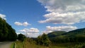 White cumulus clouds over green mountains