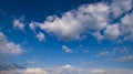 White cumulus clouds and rainbow in summer evening blue sky background Royalty Free Stock Photo