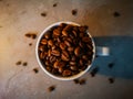 White cup of arabica and robusta coffee beans with long shadow of small kitchen lamp Royalty Free Stock Photo