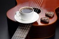 White cup with black coffee and cookies lying on the acoustic gu