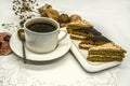 Black coffee in a white cup with a silver spoon, on a white saucer with pieces of cream cakes on a white paper lace napkin. Royalty Free Stock Photo