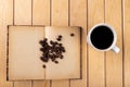 White cup with black coffee on a wooden table. Grains of coffee on an old book Royalty Free Stock Photo