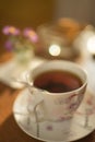 White cup of black tea with spoon on a saucer. Sunny table Royalty Free Stock Photo