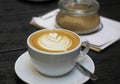 White cup of caffe latte with rosetta latte art sugar bowl with brown sugar Royalty Free Stock Photo