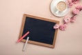 White cup with cappuccino, sakura flowers, chalk board on a past Royalty Free Stock Photo