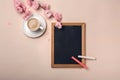 White cup with cappuccino, sakura flowers, chalk board on a past Royalty Free Stock Photo