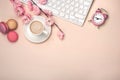 White cup with cappuccino, sakura flowers, keyboard, macarons, a Royalty Free Stock Photo