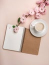 White cup with cappuccino, sakura flowers, notebook on a pastel pink background . Mother`s day Royalty Free Stock Photo