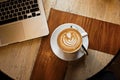 White cup of cappuccino on a wooden table Royalty Free Stock Photo