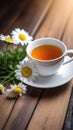 White cup with chamomile tea on a wooden table. There are chamomile flowers nearby. Copy space, place for text, empty Royalty Free Stock Photo