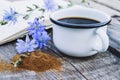 White cup with chicory drink and flowers near chicory powder. Tea from chicory. Healthy eating concept Royalty Free Stock Photo