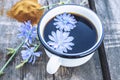 White cup with chicory drink and flowers near chicory powder. Tea from chicory. Healthy eating concept Royalty Free Stock Photo