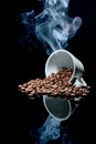 A white cup with coffee beans falling out and steam rising from it reflecting in the glass Royalty Free Stock Photo