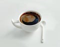 White cup of coffee and white ceramic spoon on a white background Royalty Free Stock Photo